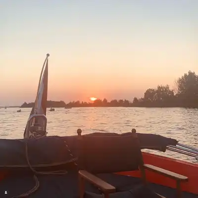 Heerlijkdagje luxe sloep varen in Loosdrecht tijdens een spectaculaire zonsondergang op de plassen